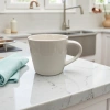This white ceramic cup is a simple household water cup with a smooth glaze surface after high-temperature firing details Picture